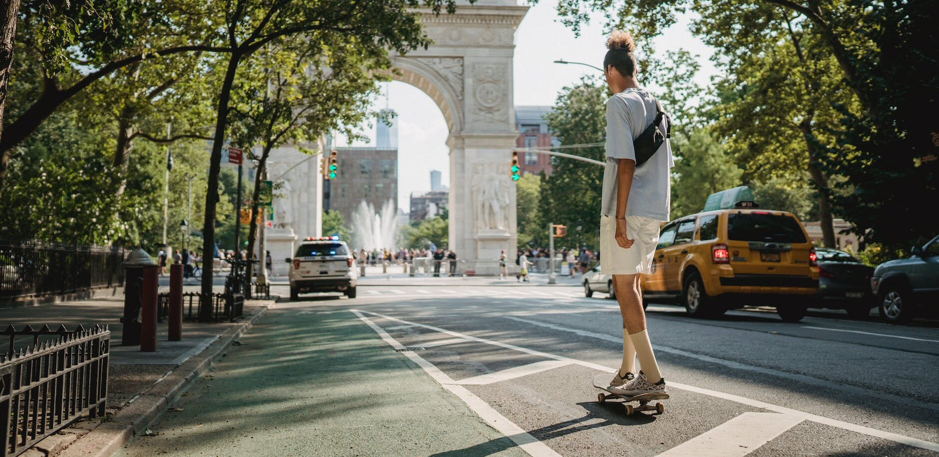 unrecognizable sporty guy riding skateboard on city street in daylight